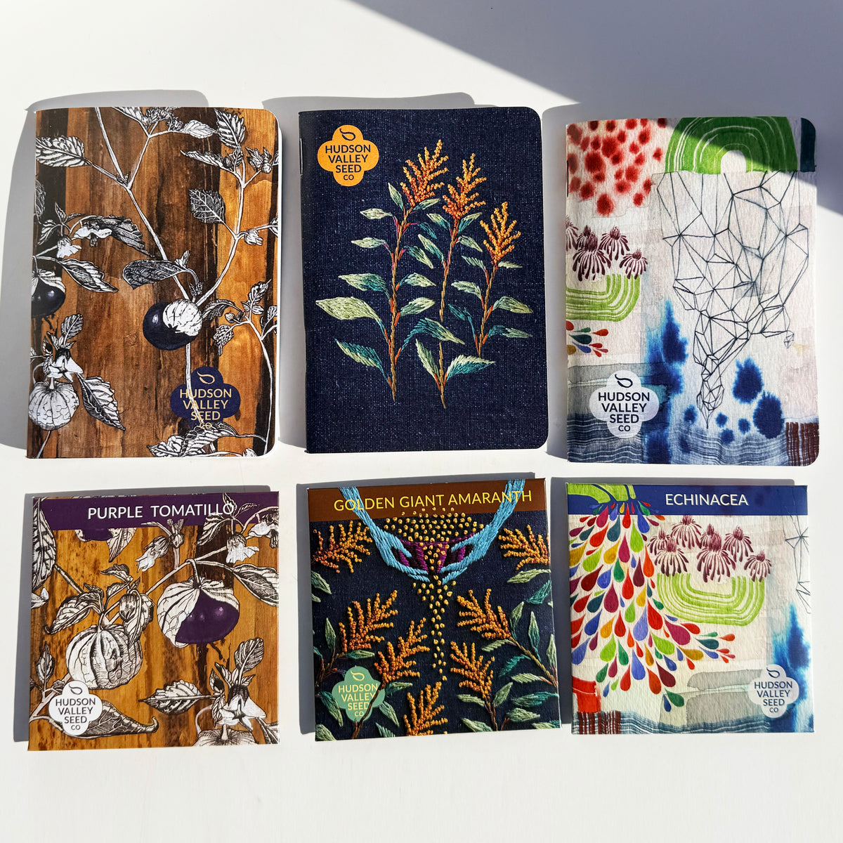 Three garden-themed notebooks in the HVSC Garden Notebook Trio, featuring colorful covers and nature-inspired designs.