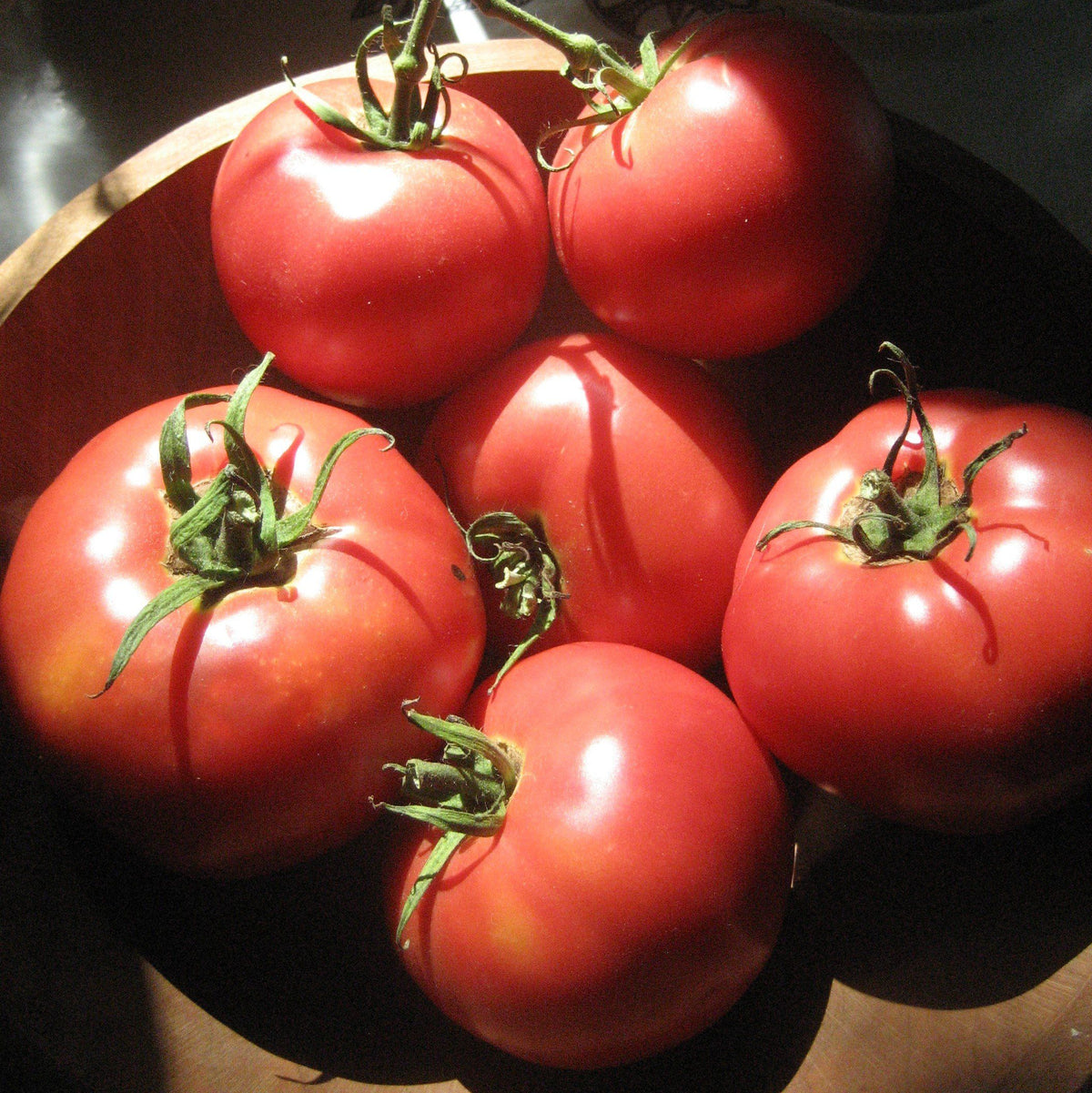 Vivid Rose de Berne tomato from Hudson Valley Seed Co displayed at a vendor stall, showcasing its unique shape and vibrant color.