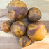 Fresh Masquerade Potatoes from Hudson Valley Seed Co., showcasing their vibrant, colorful skin and round vegetable shape.