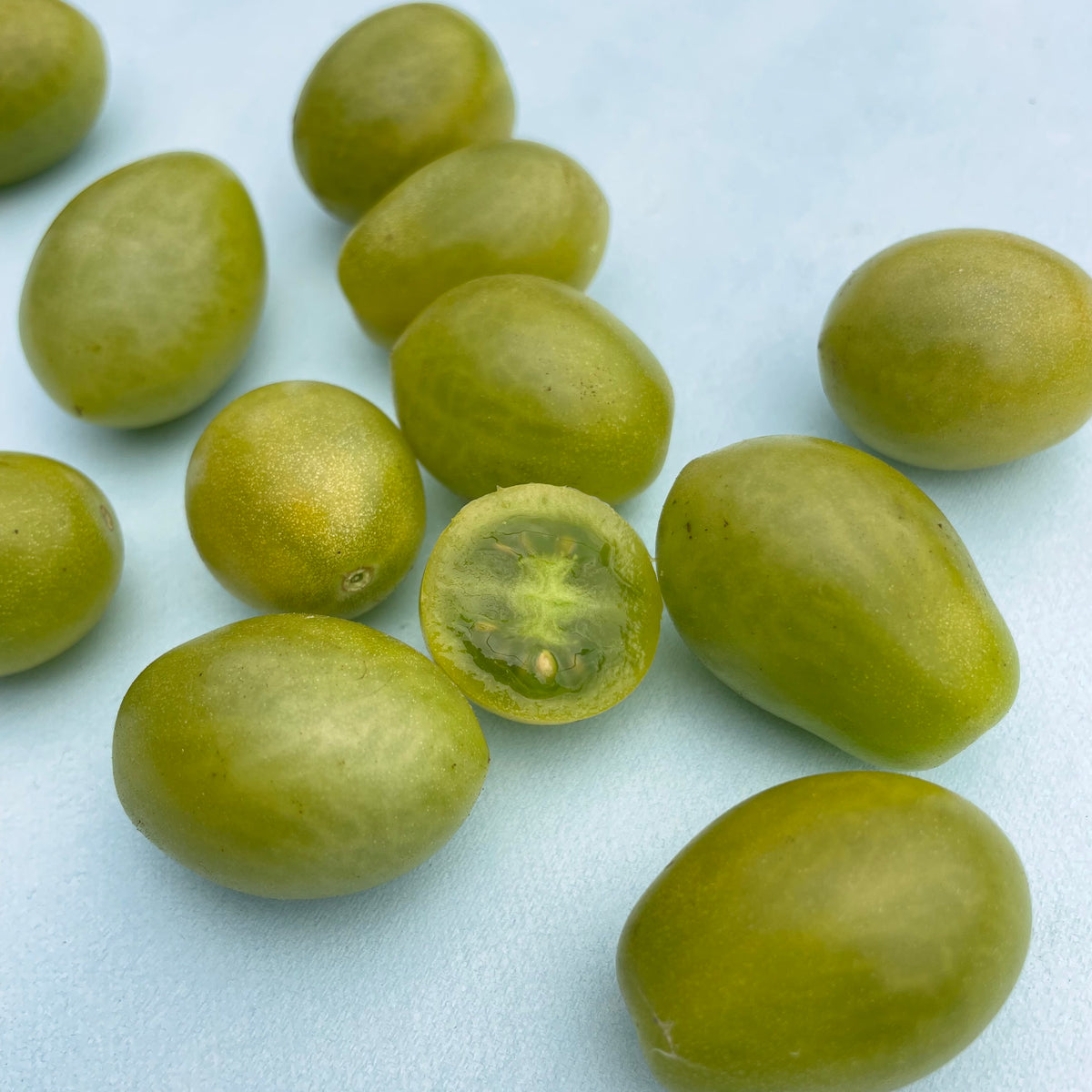 Fresh green grape tomatoes from vendor-unknown, showing small, round, bright green vegetables ideal for salads and snacking.