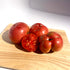 Hudson Valley Seed Co. Mortgage Lifter Tomato vegetable with large, ripe red fruit and lush green foliage in a garden setting.