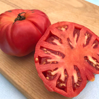 Prudens Purple Tomato from Hudson Valley Seed Co., vibrant purple heirloom vegetable with smooth skin and ripe, round shape.
