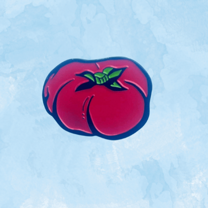 Mikado Tomato enamel pin from a gift shop, featuring a bright red tomato design on a metal pin back.