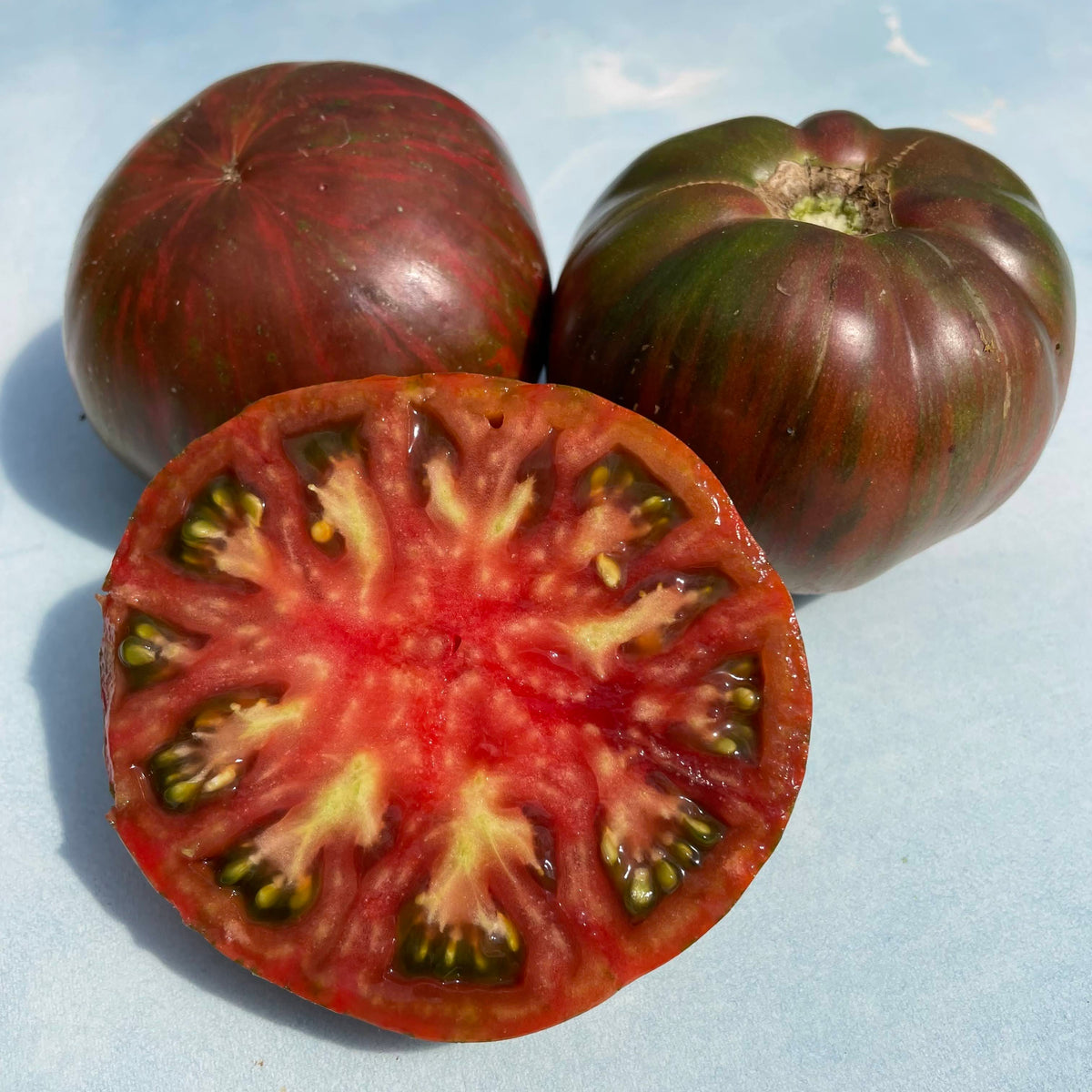 Vibrant pink tie-dye Berkeley tomato, fresh vegetable with colorful skin, from vendor-unknown.