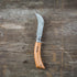 Opinel folding harvest knife with wooden handle and stainless steel blade, ideal for gardening and harvesting tasks.
