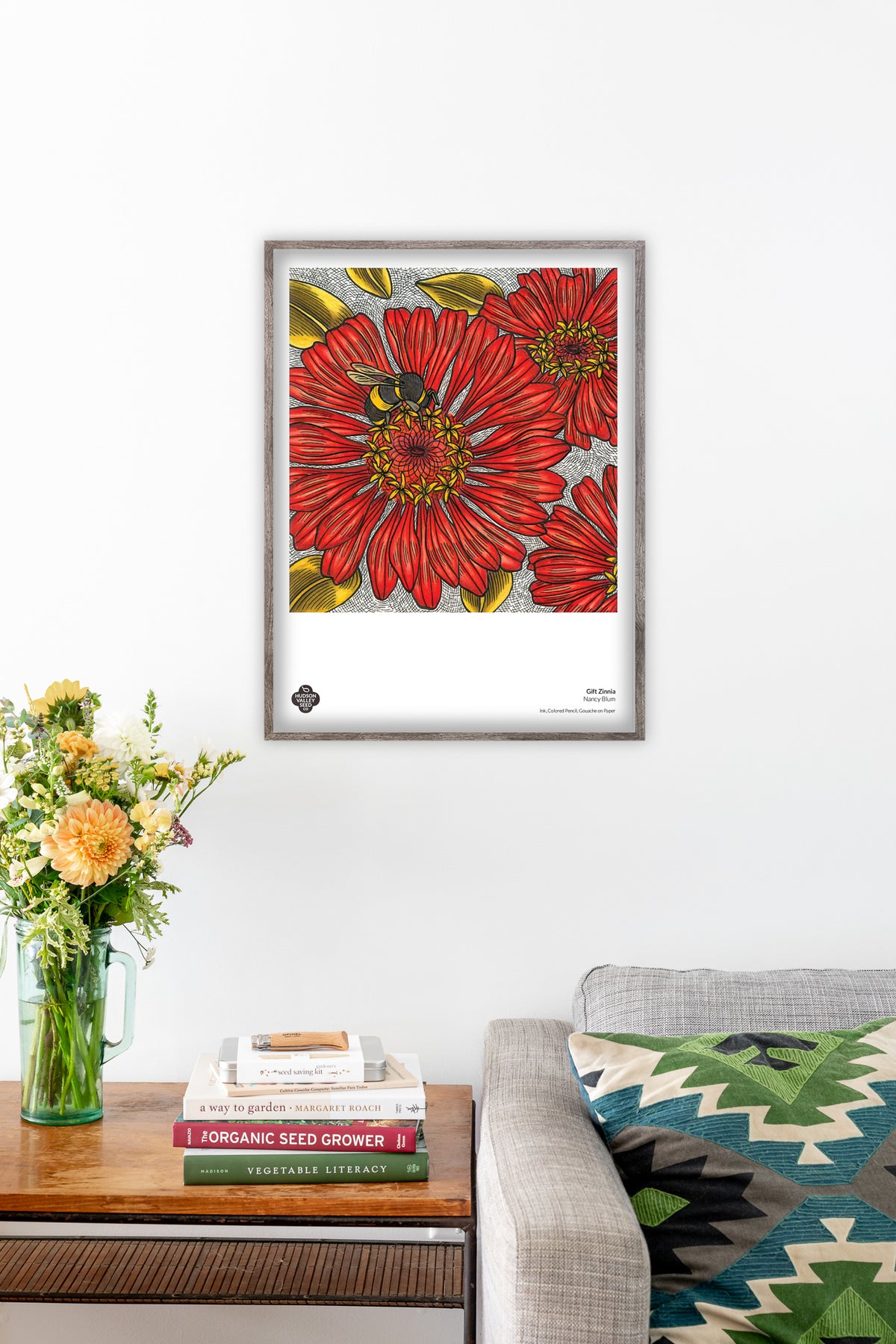 Fine art poster of vibrant zinnia flowers by Hudson Valley Seed Co. displayed in a living room setting.
