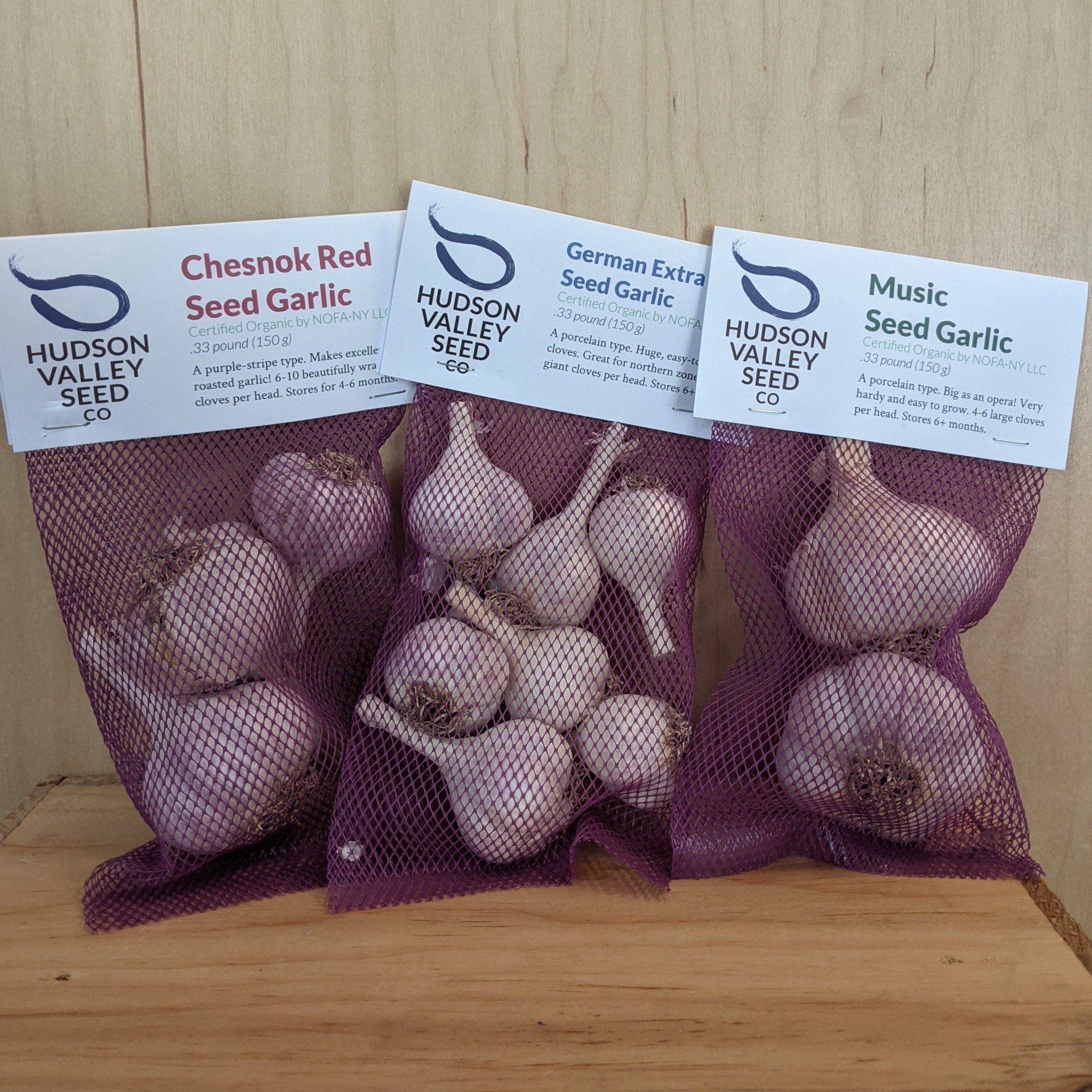 Hardneck garlic variety pack with multiple garlic bulbs from Hudson Valley Seed Co., displayed on a rustic wooden surface.