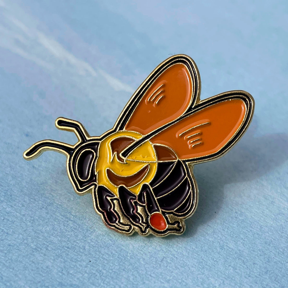Enamel pin featuring a bee design from Hudson Valley Seed Co., perfect for gift shop accessories.