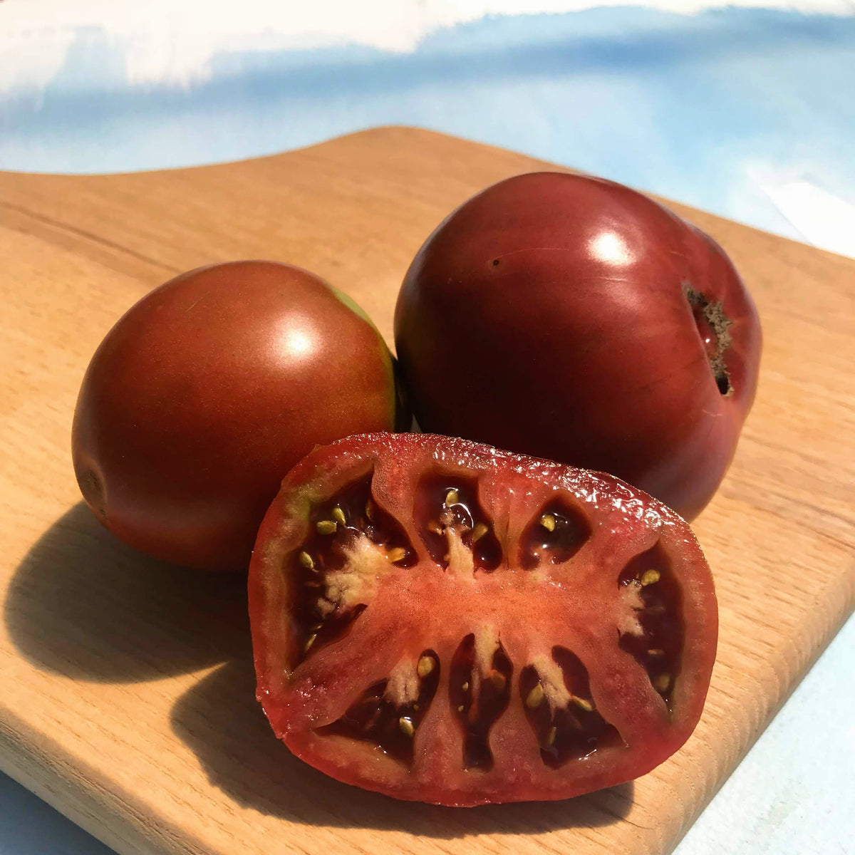Japanese Black Trifele tomato from Hudson Valley Seed Co., showing dark, oblong heirloom tomatoes on a vendor&