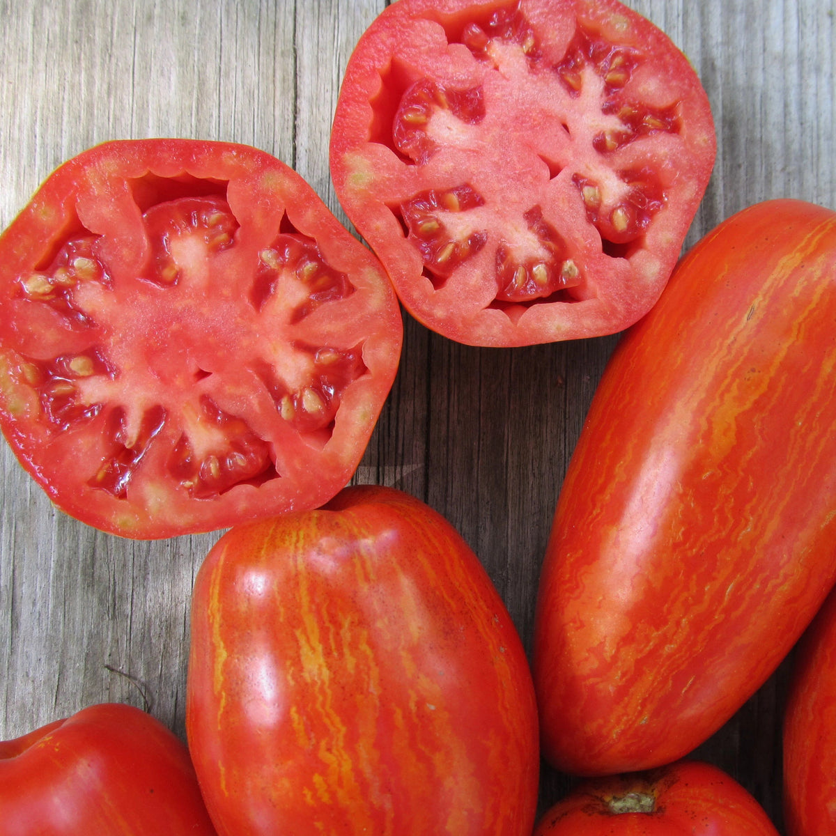 Speckled Roman tomato from Hudson Valley Seed Co., vibrant red and yellow speckled vegetable on a market stand.